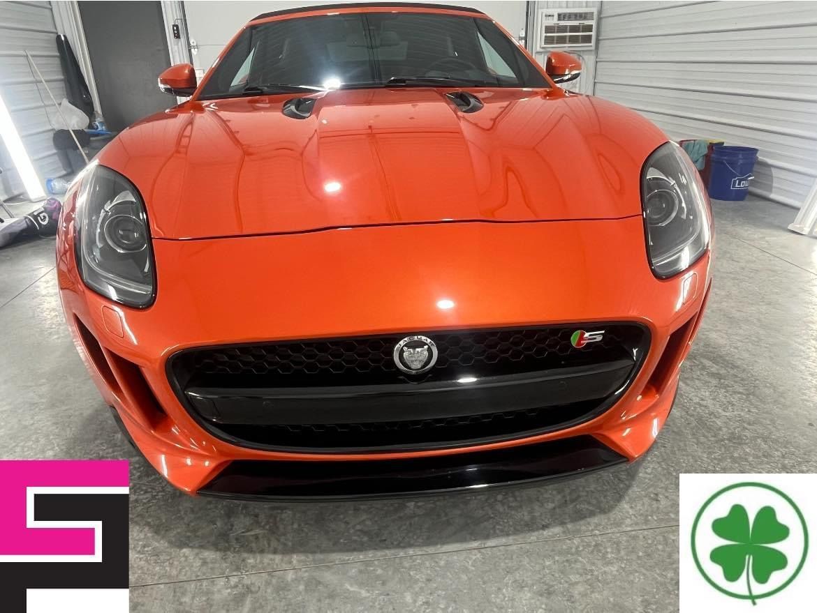 A red jaguar f type is parked in a garage.