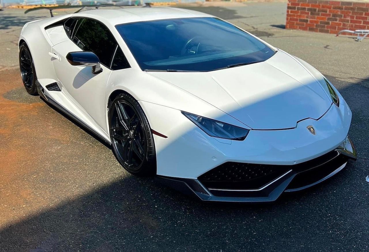 A white lamborghini huracan is parked in a parking lot.