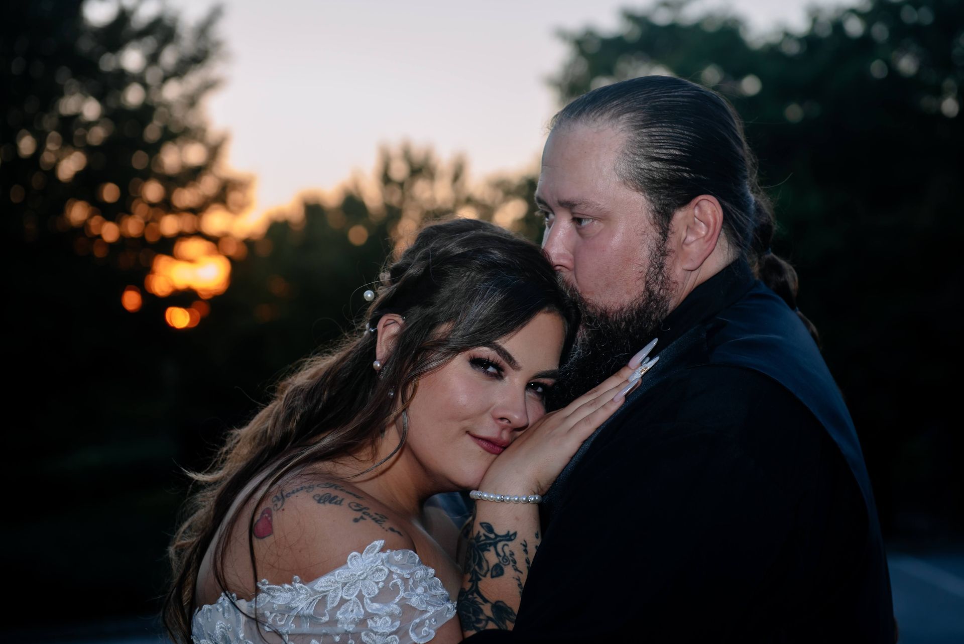 A bride and groom are posing for a picture at their wedding.