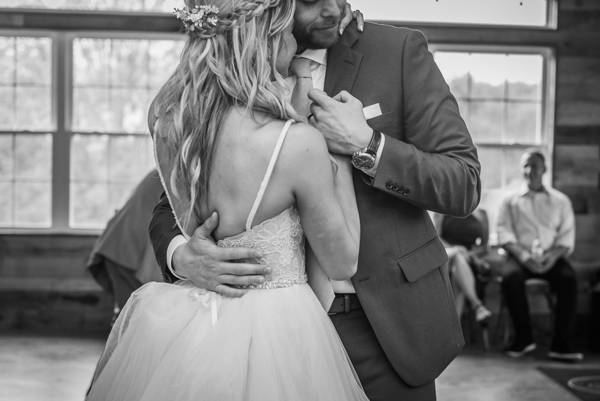 A black and white photo of a bride and groom dancing at their wedding reception.
