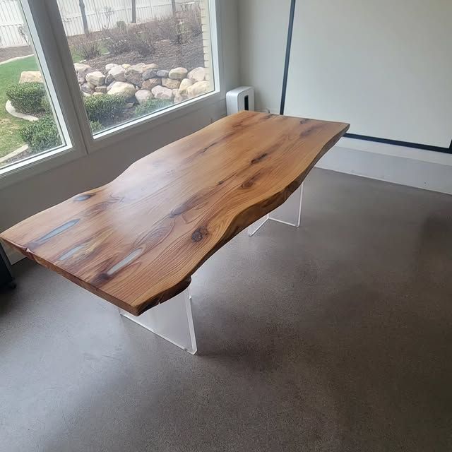 A wooden table sits in a room next to a window