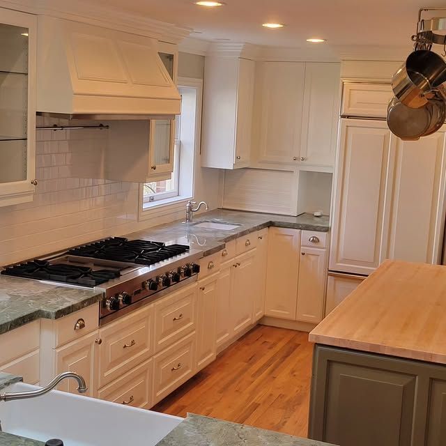 A kitchen with white cabinets and a stove top oven