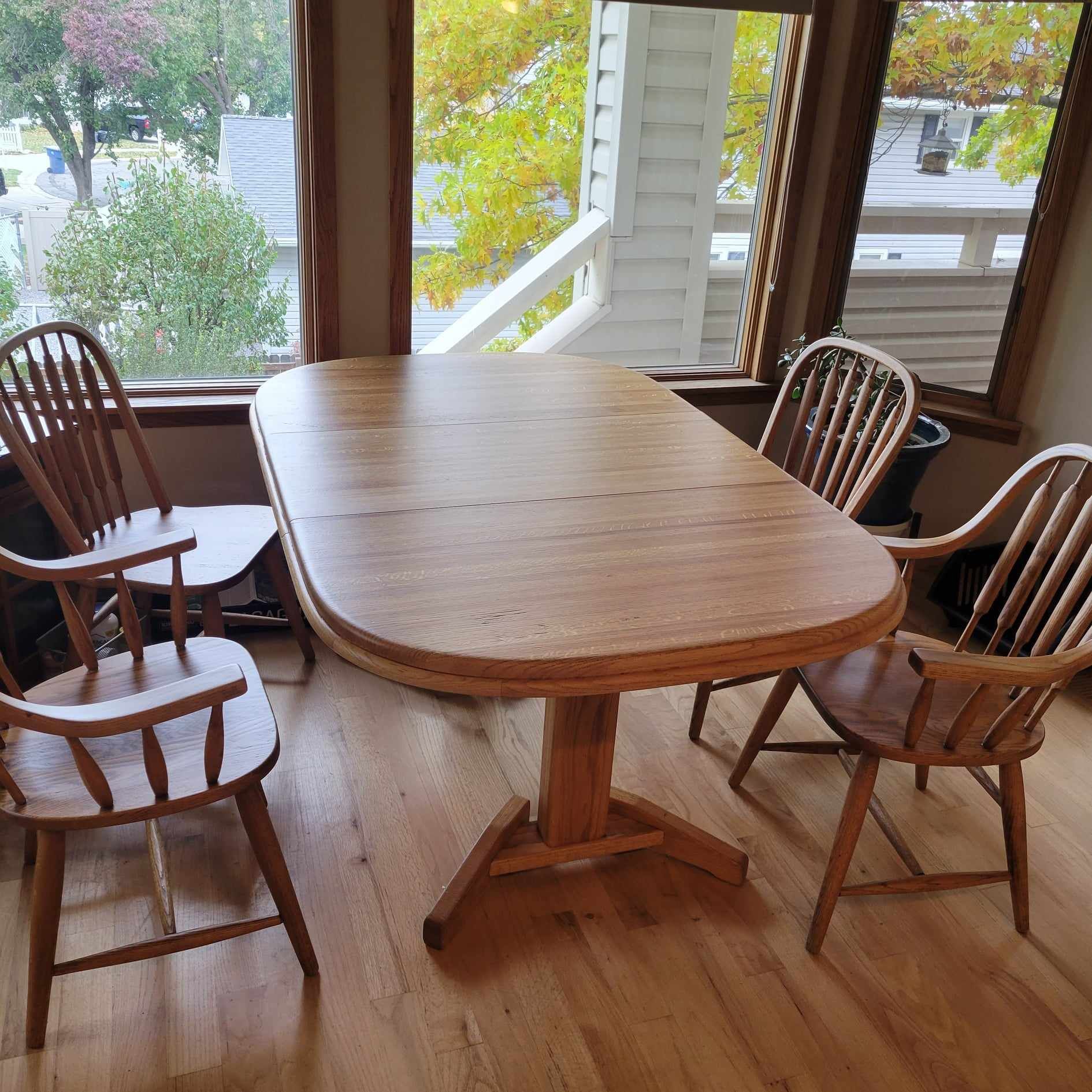 A wooden table and chairs in front of a window
