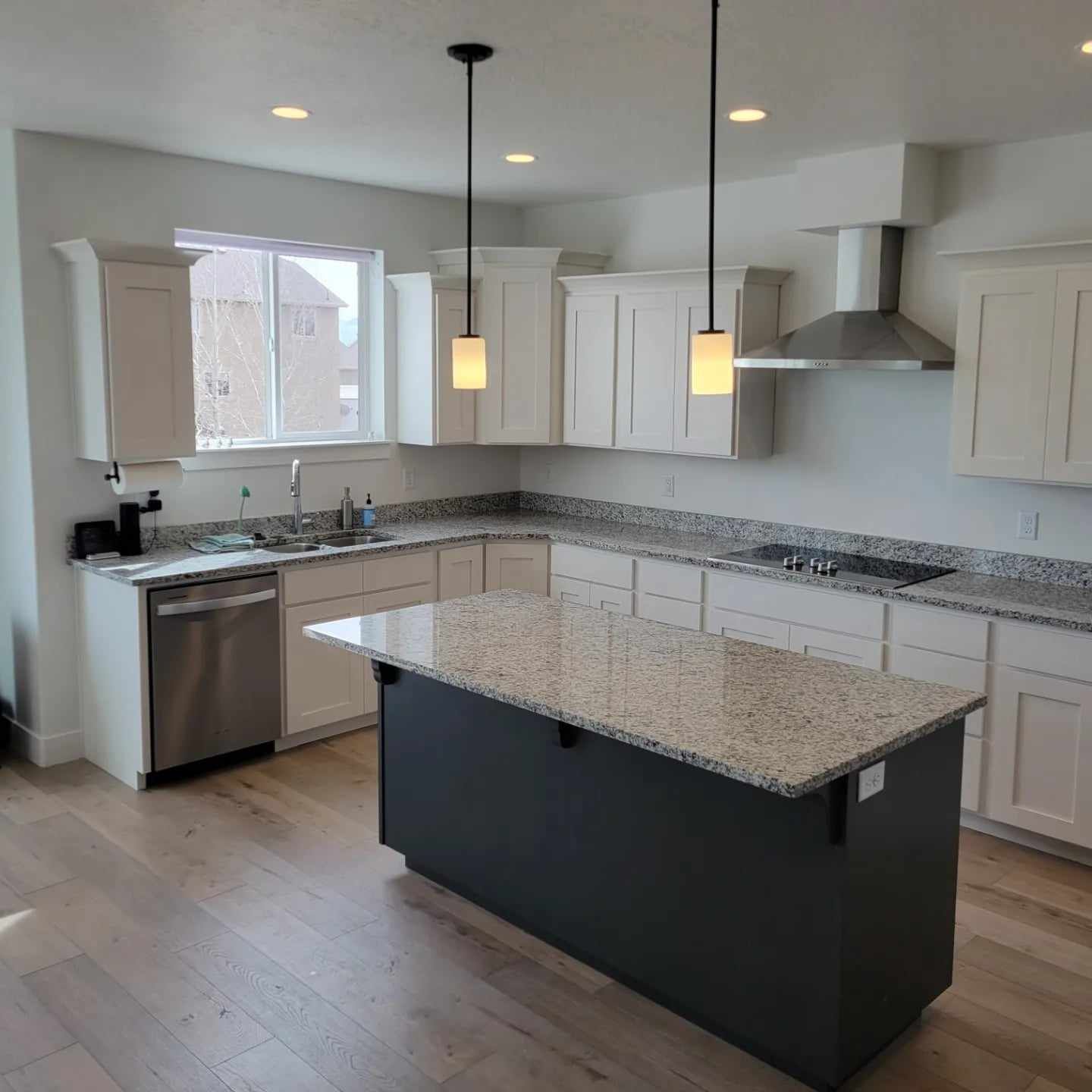 A kitchen with white cabinets and granite counter tops