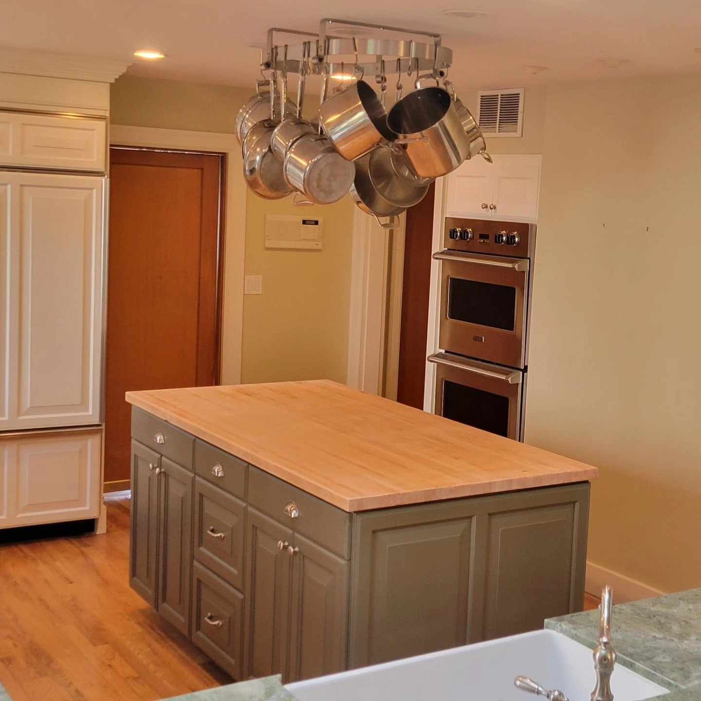 A kitchen with pots and pans hanging from the ceiling