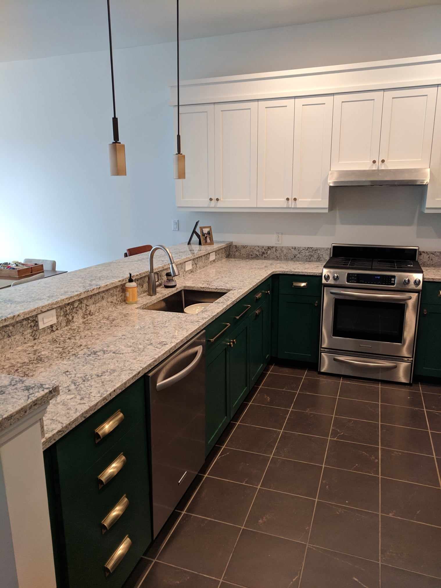 A kitchen with green cabinets and stainless steel appliances