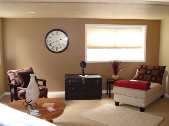 A living room with a clock on the wall that shows the time as 4:20