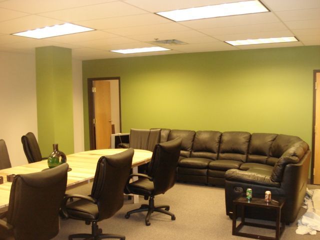 A reception area with red walls and a white counter