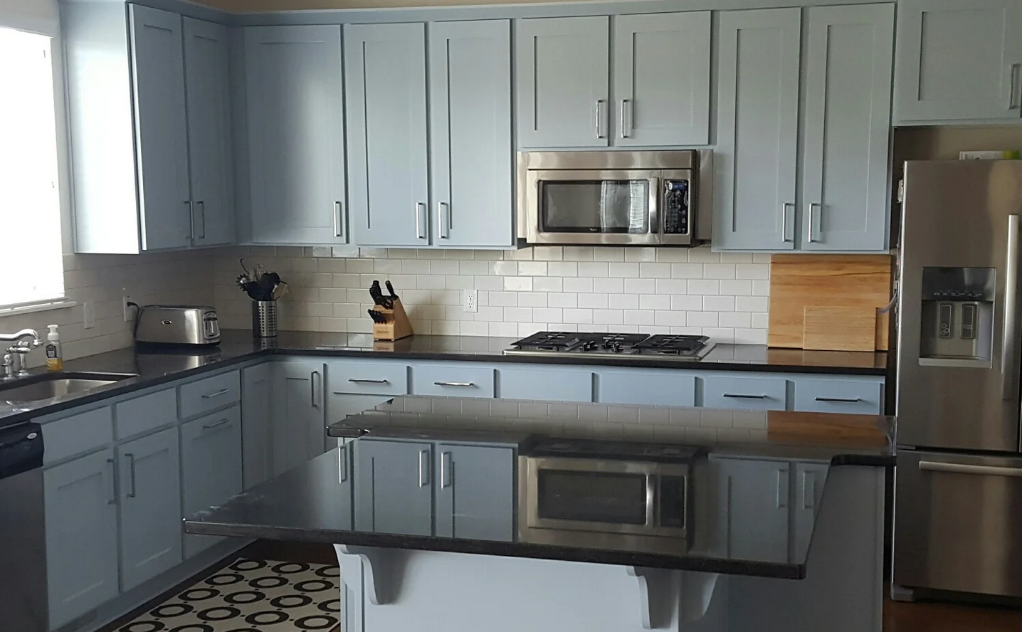 A kitchen with stainless steel appliances and blue cabinets