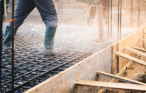 A man is pouring concrete on a construction site.