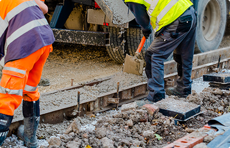 A group of construction workers are working on a road.