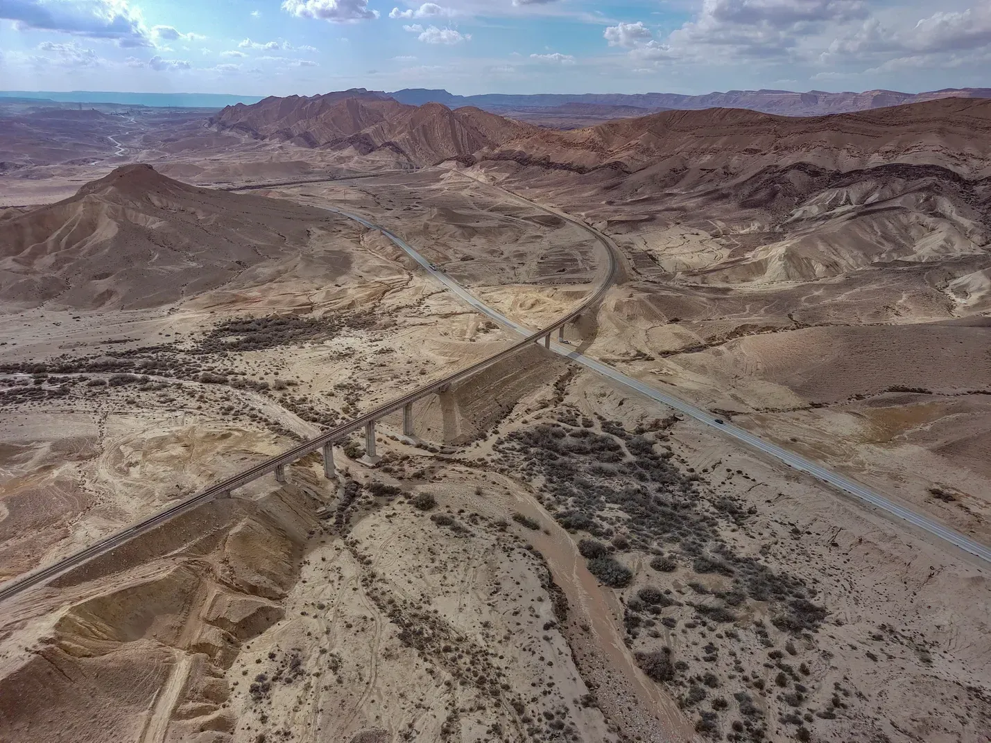 An aerial view of a desert landscape with mountains in the background.