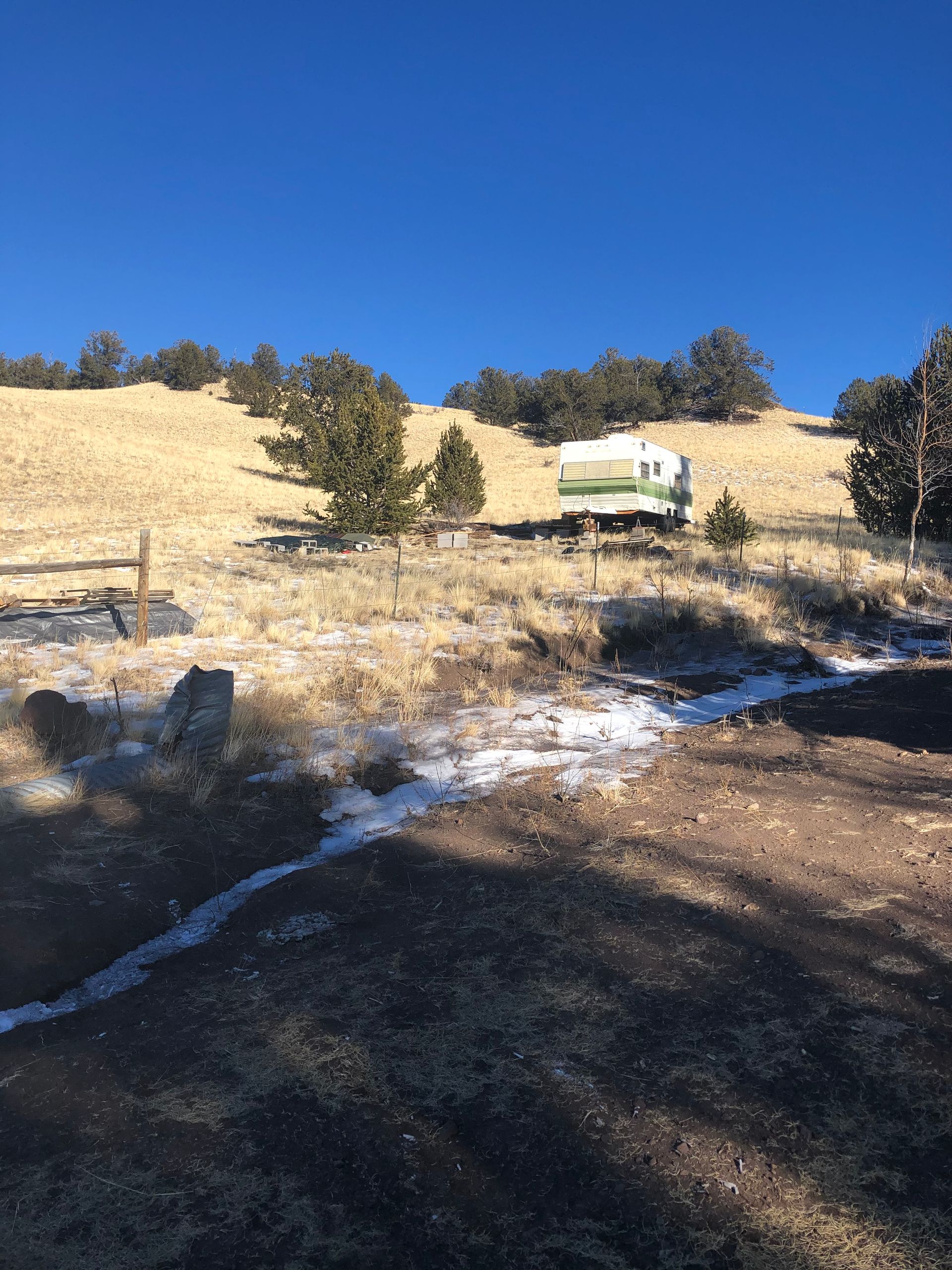 A rv is parked on top of a grassy hill.