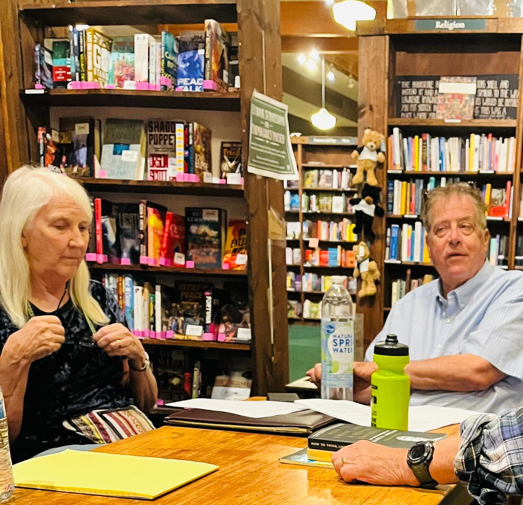 A man and a woman are sitting at a table in a bookstore