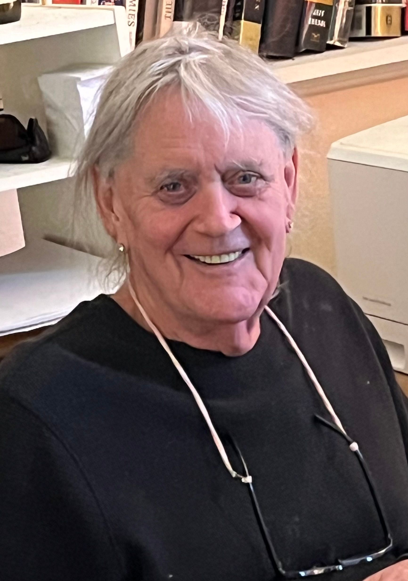 A man wearing glasses and a black shirt is smiling for the camera.