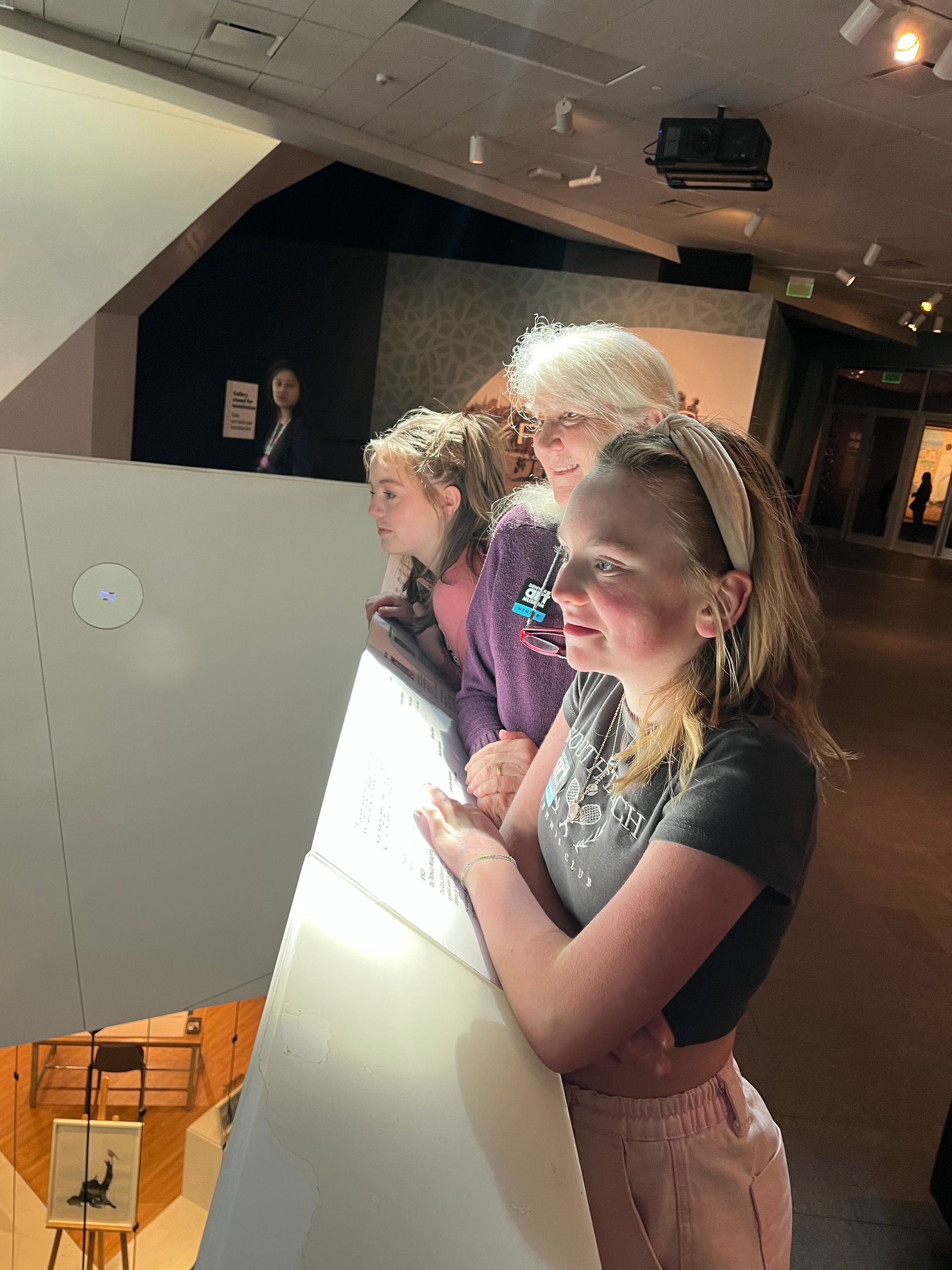 A group of young girls are looking at a display in a museum.