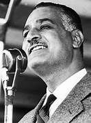 A man in a suit and tie is singing into a microphone.