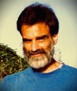 A man with a beard is wearing a blue shirt.