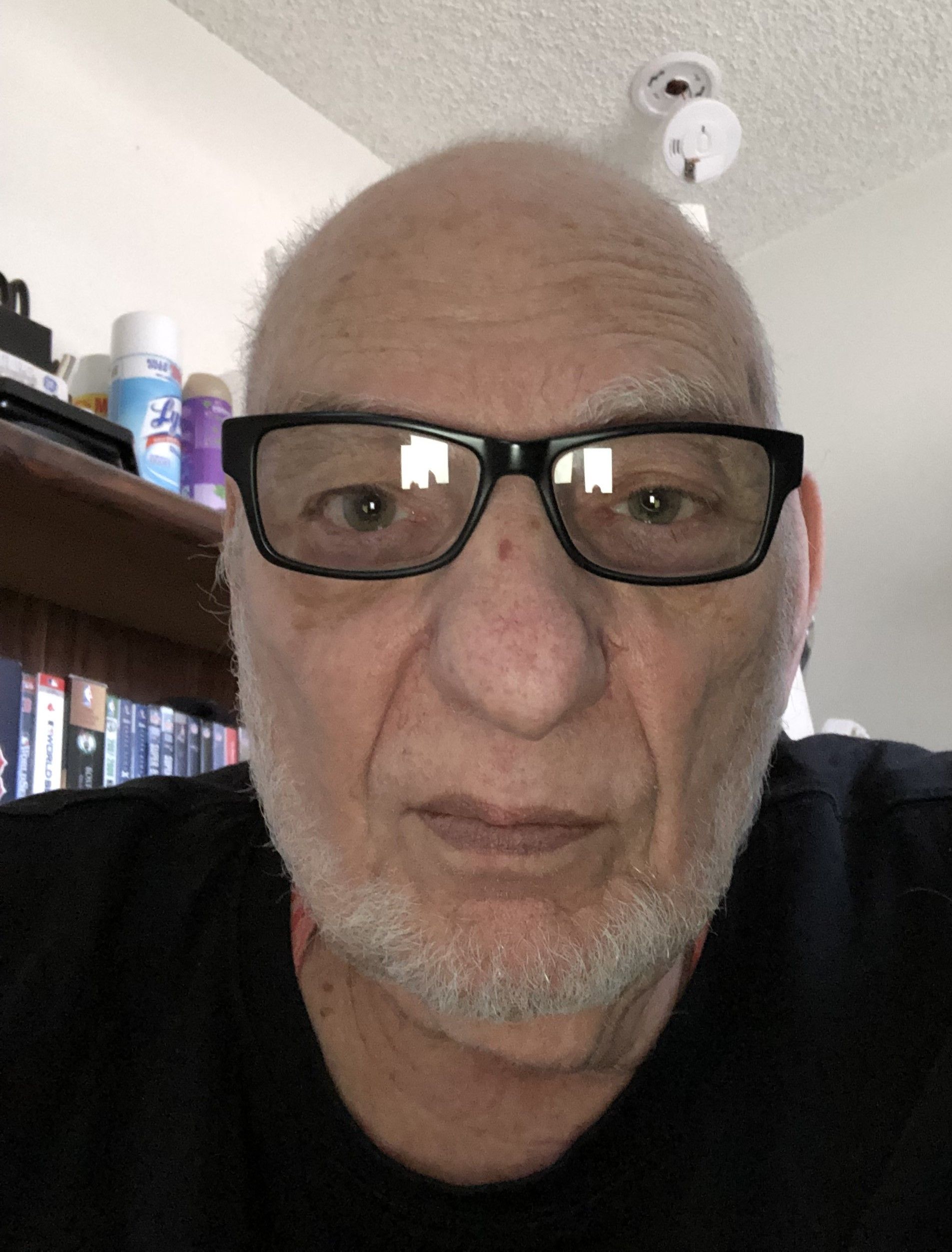 A man with glasses and a beard is looking at the camera.