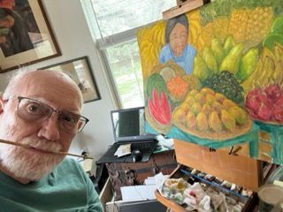 A man is taking a selfie in front of a painting of fruits and vegetables.