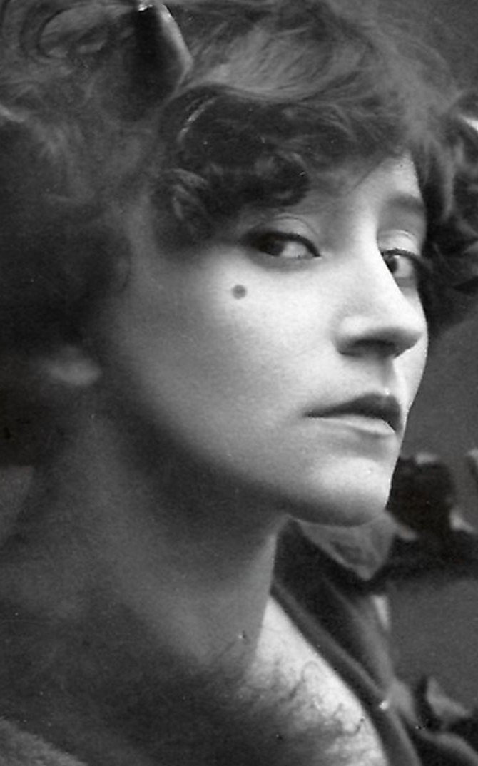 A black and white photo of a woman with curlers in her hair.