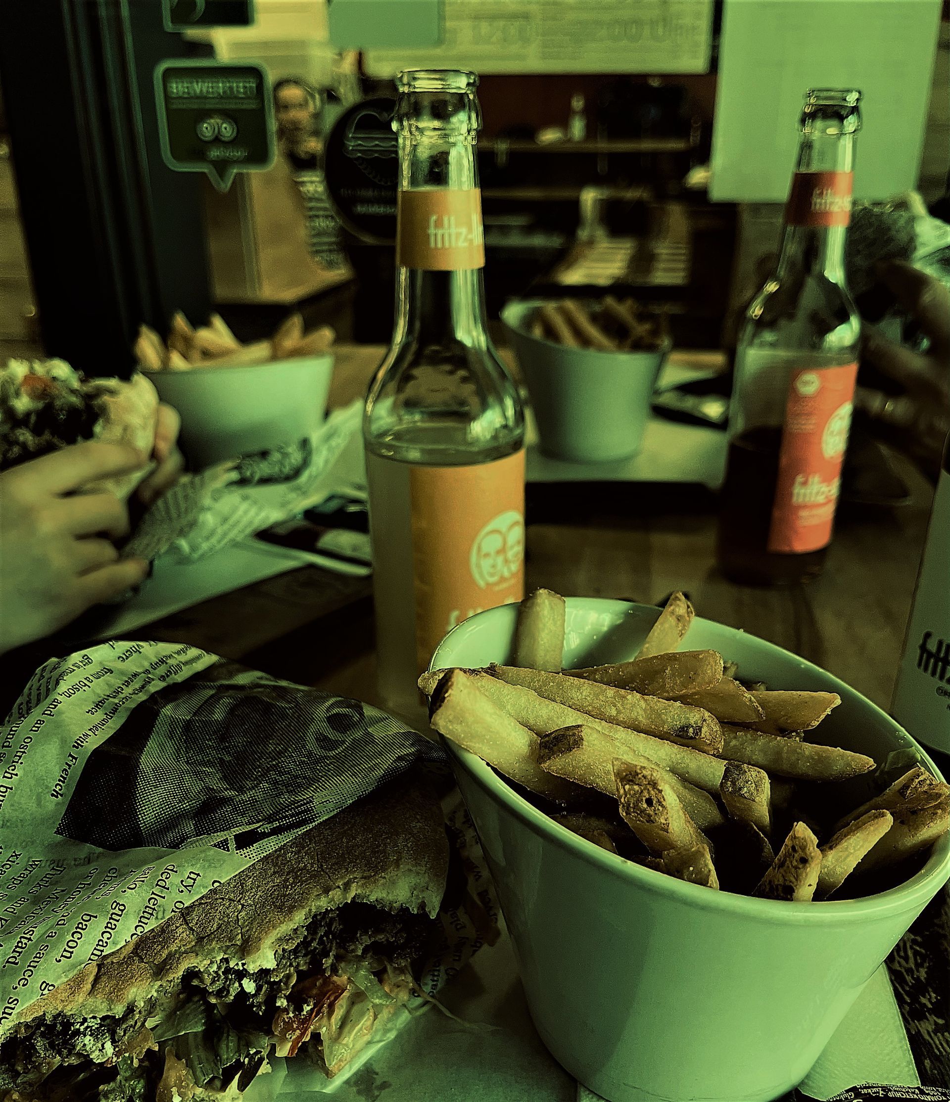 A bowl of french fries next to a bottle of corona