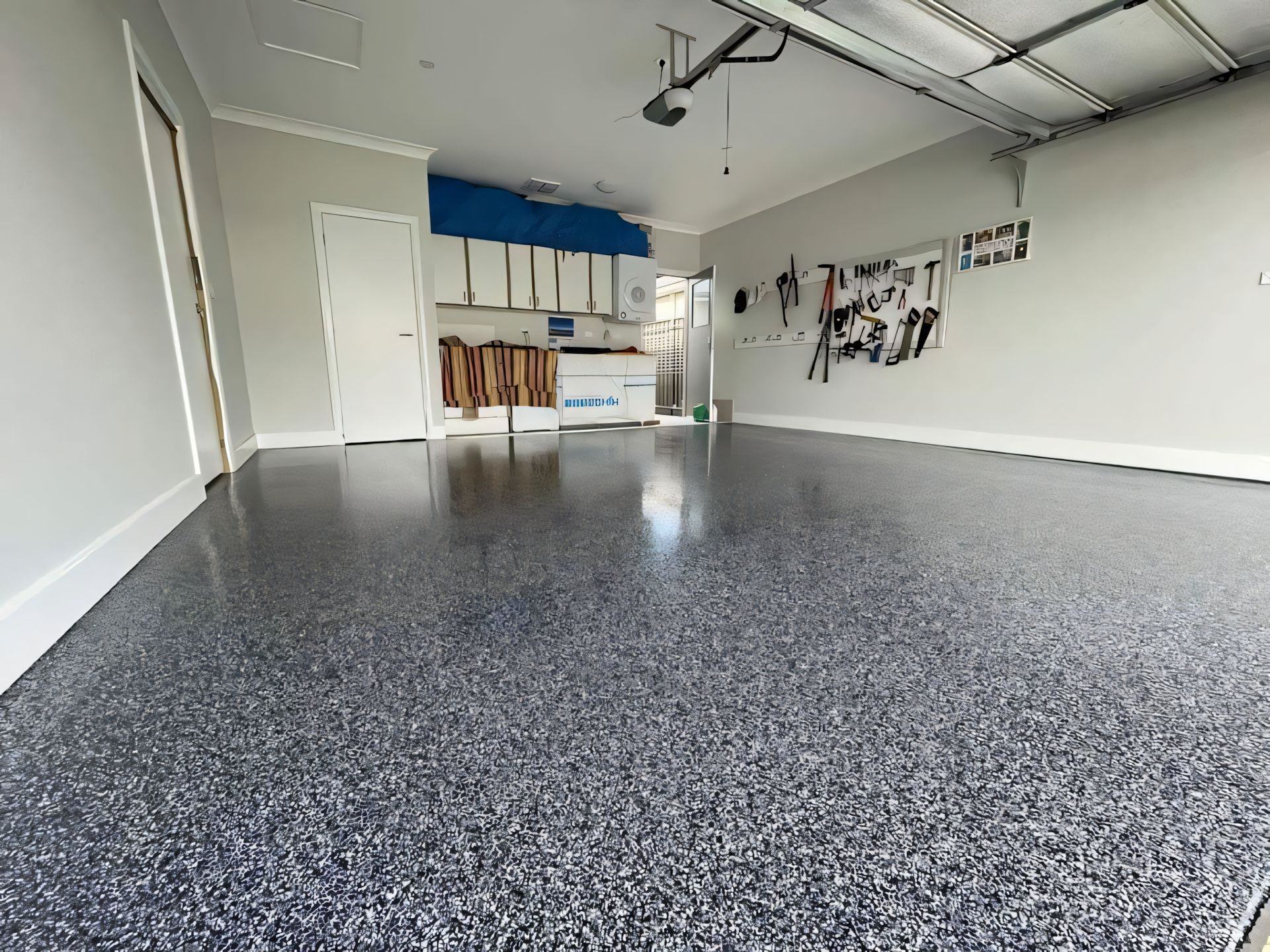 A garage with a gray floor and a garage door open. — Partlic Painting & Epoxy Flooring In Wingham, NSW