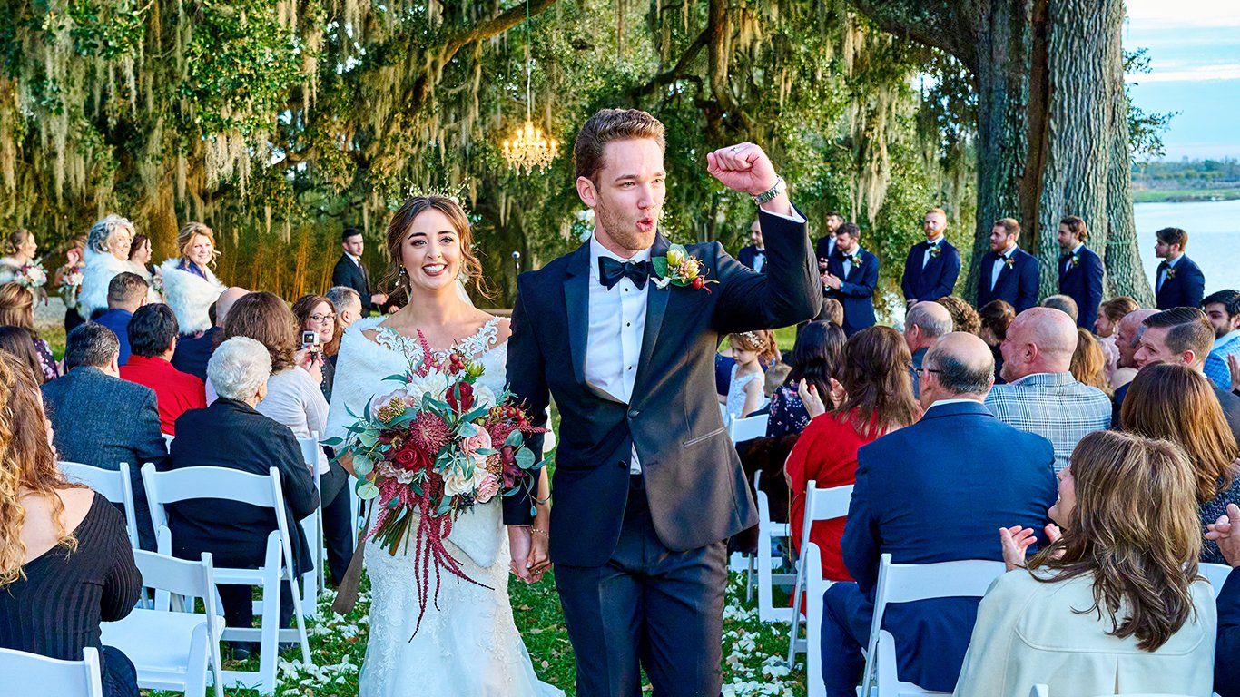 A bride and groom are walking down the aisle at their wedding.