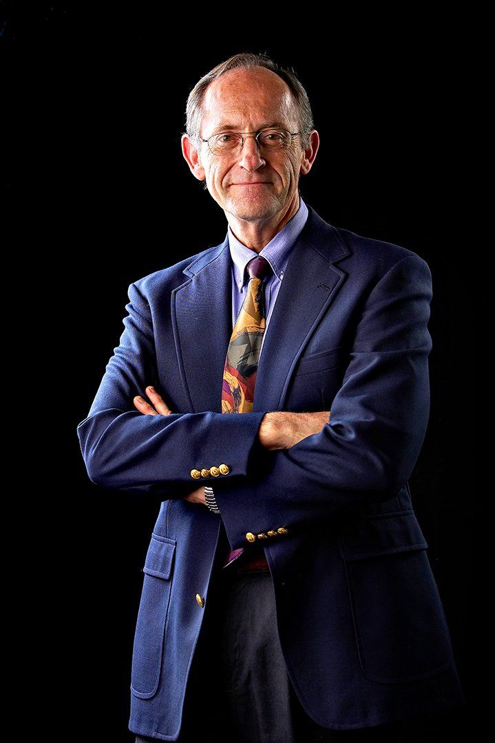 A man in a suit and tie with his arms crossed