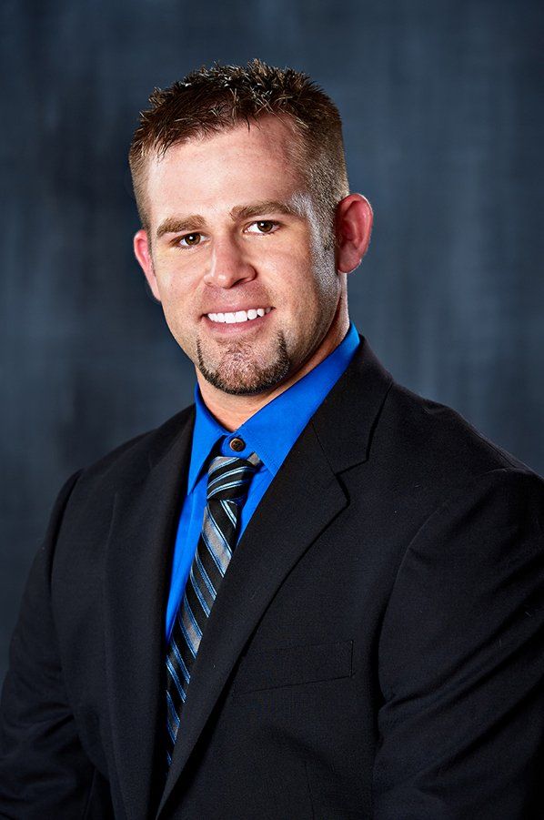 A man in a suit and tie is smiling for the camera.