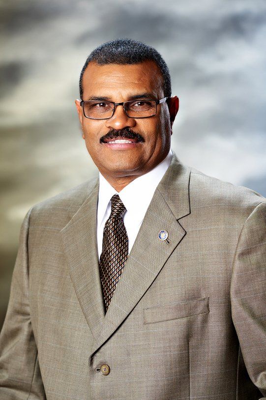 A man in a suit and tie is smiling for the camera