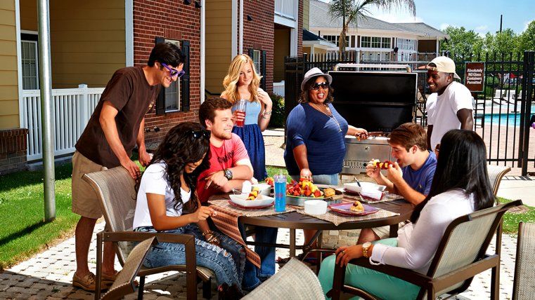 A group of people are sitting around a table eating food.