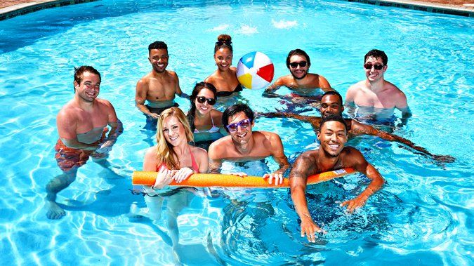 A group of people are swimming in a swimming pool.