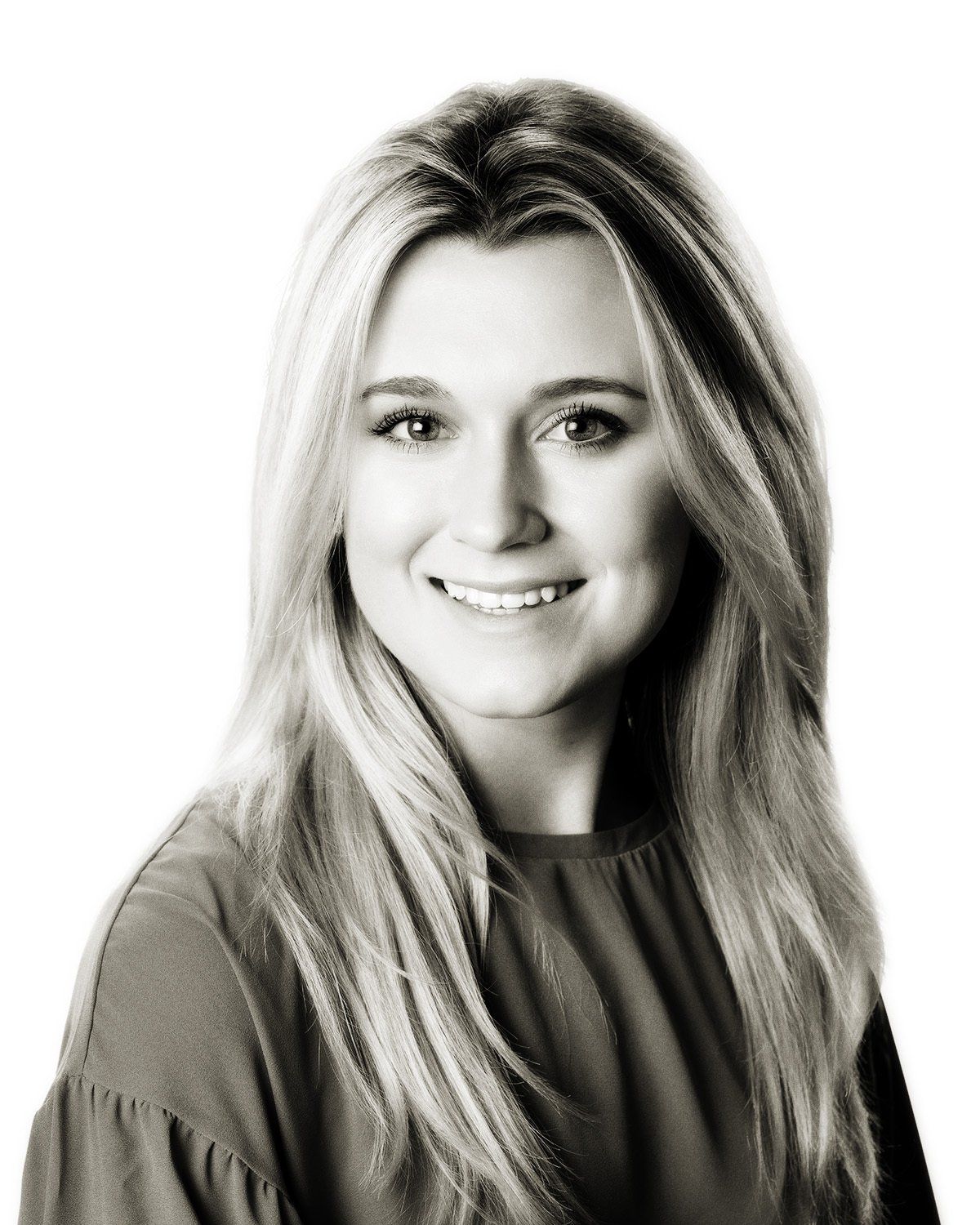 A woman with long blonde hair is smiling in a black and white photo