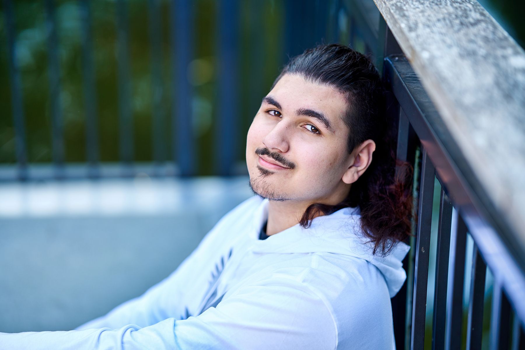 A woman in a hat is holding a bulldog in her lap.