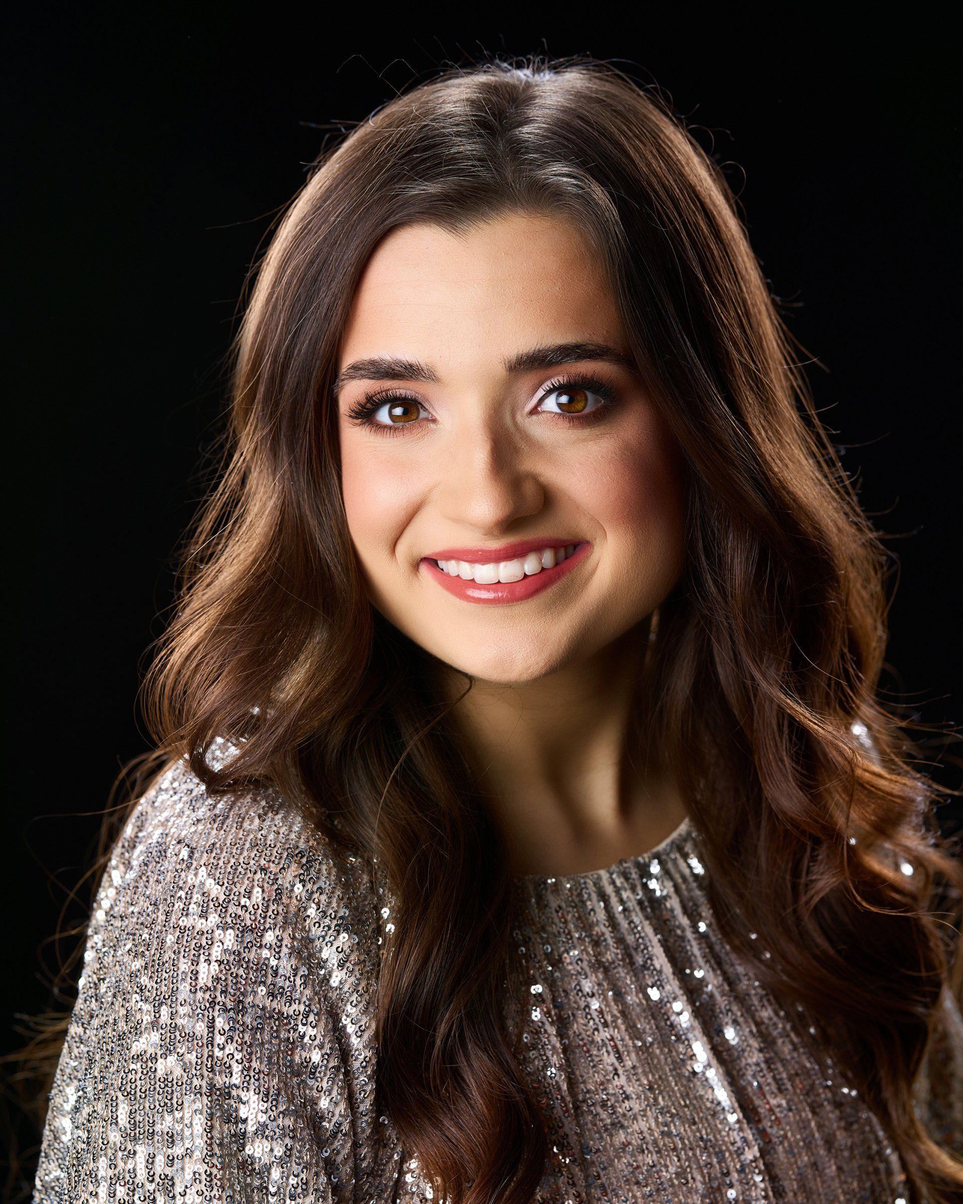 A woman in a sequined dress is smiling for the camera.