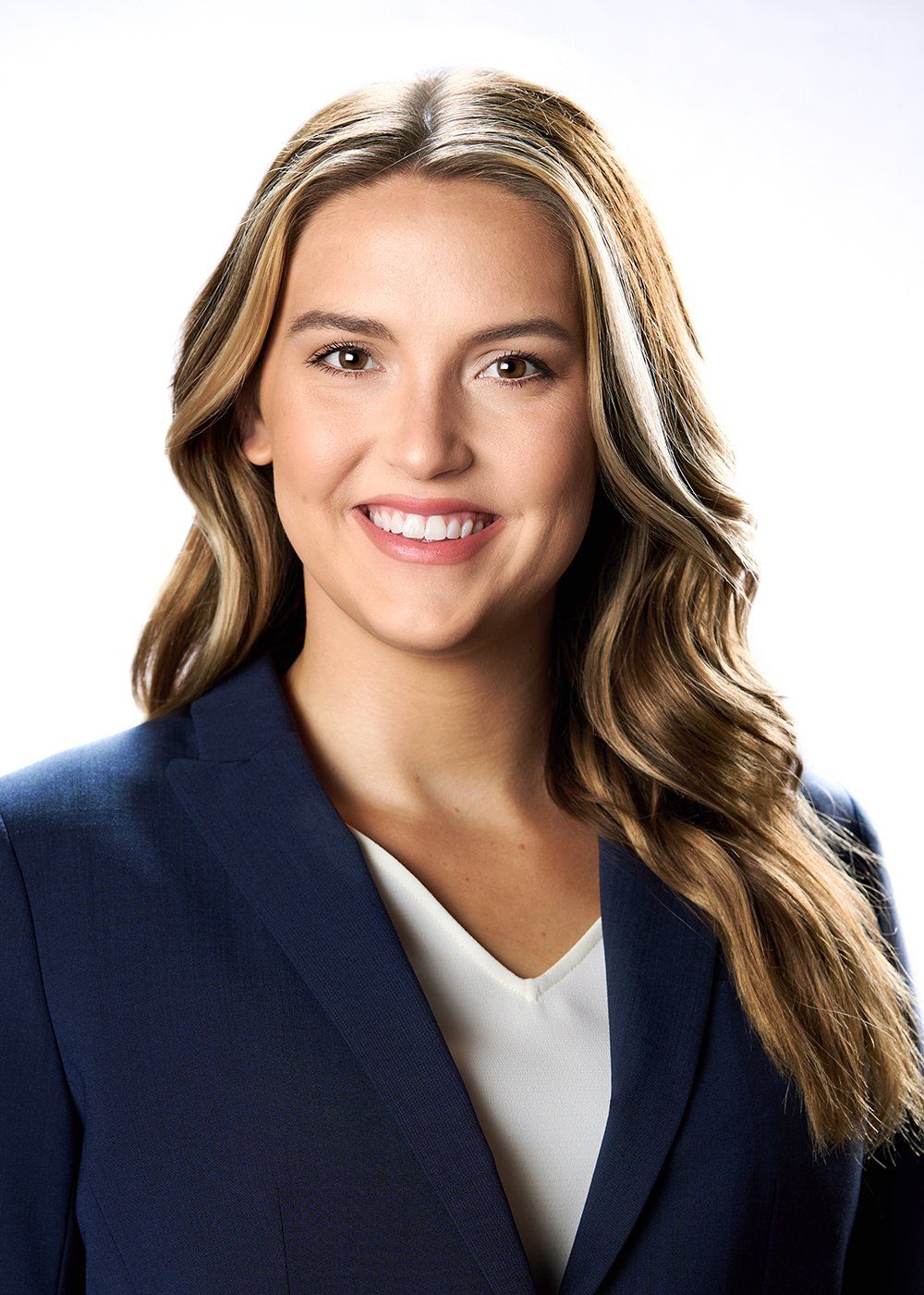 A woman in a blue jacket and white shirt is smiling for the camera.