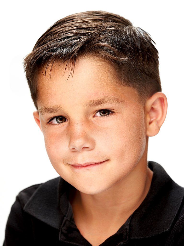 A young boy wearing a black shirt is smiling for the camera