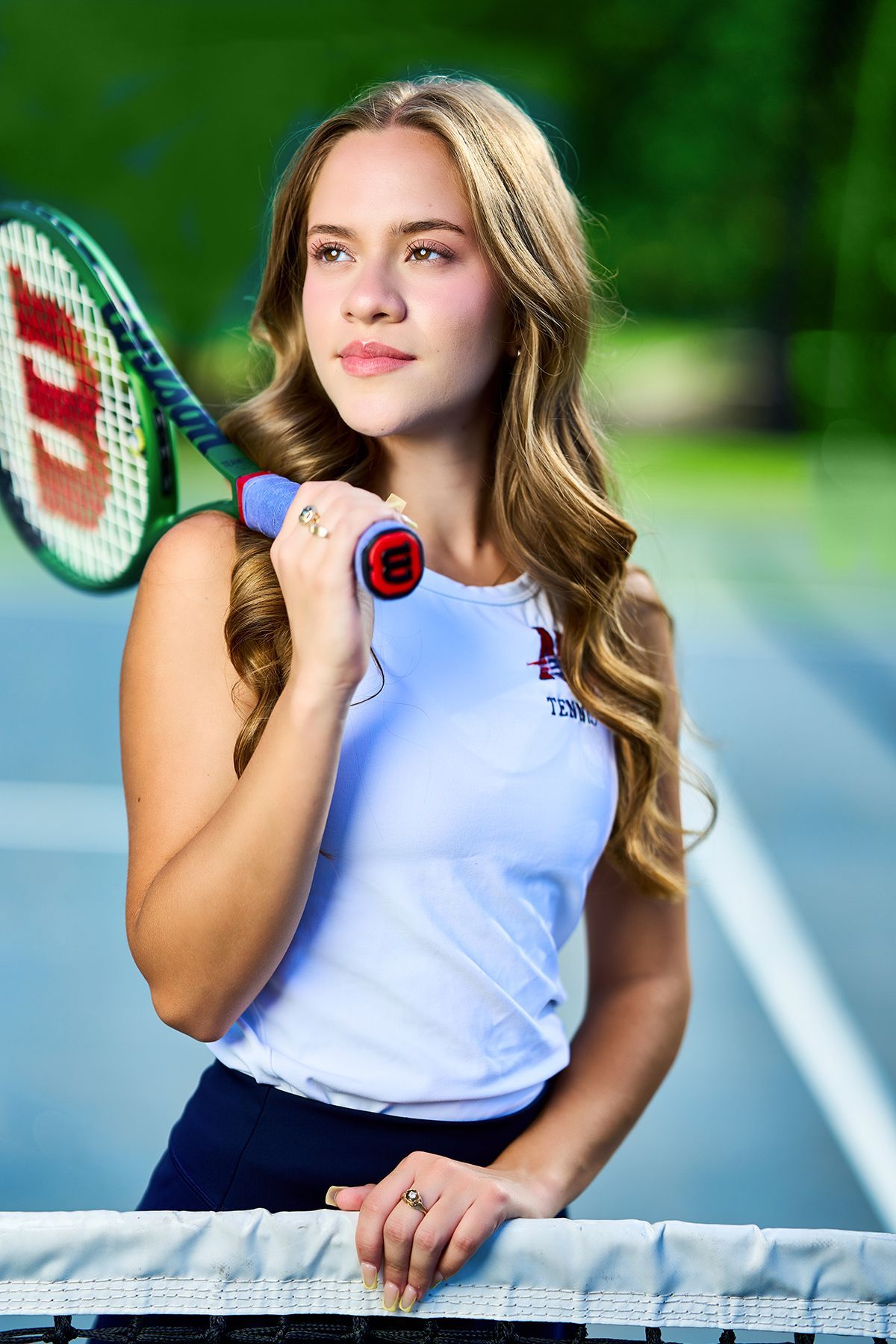 A woman wearing a green and white letterman jacket with the letter e on it.