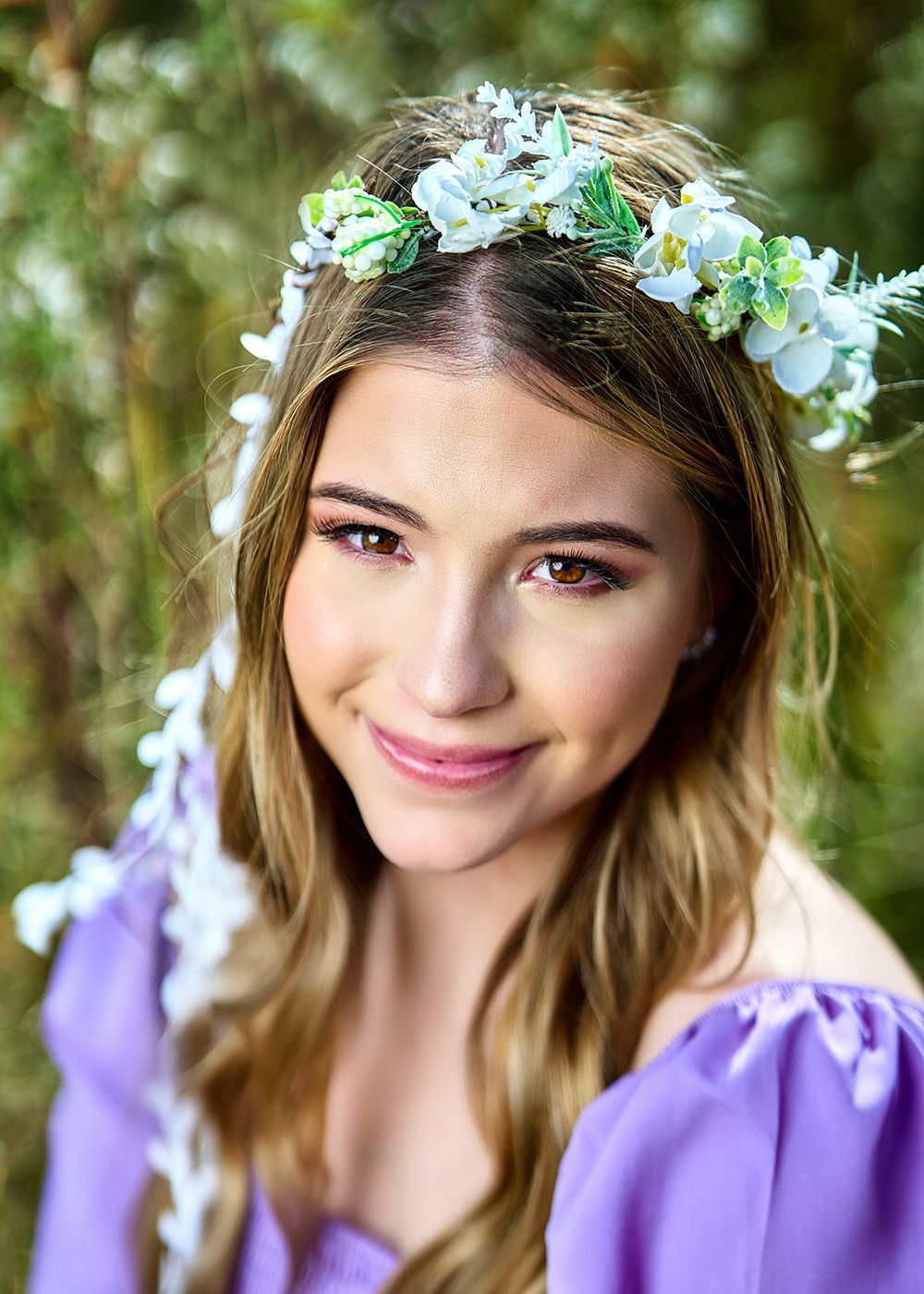 A woman in a purple dress is wearing a flower crown on her head.