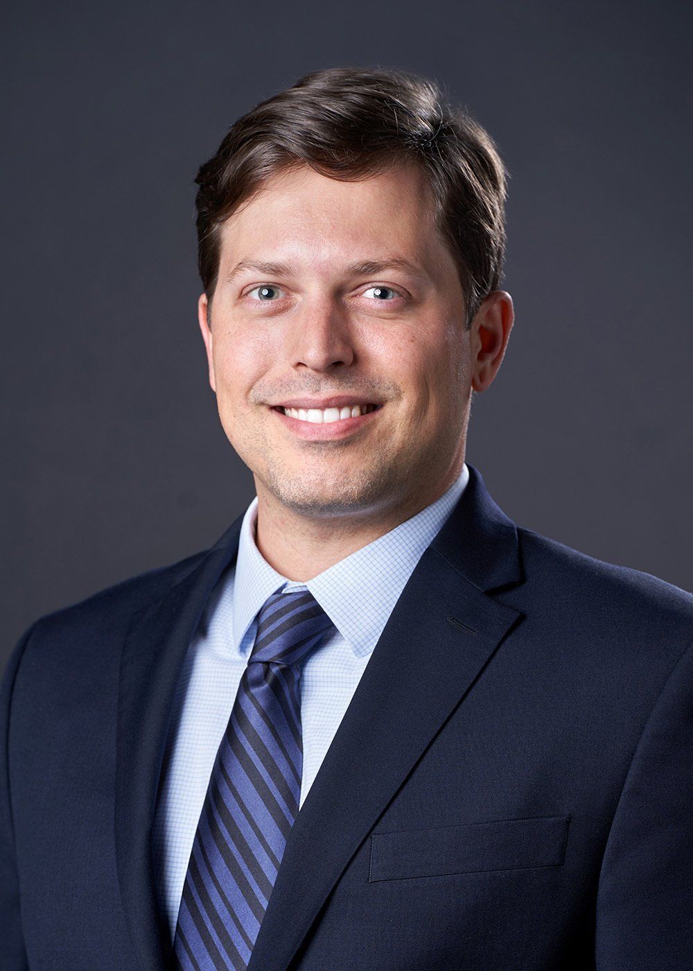 A man in a suit and tie is smiling for the camera.