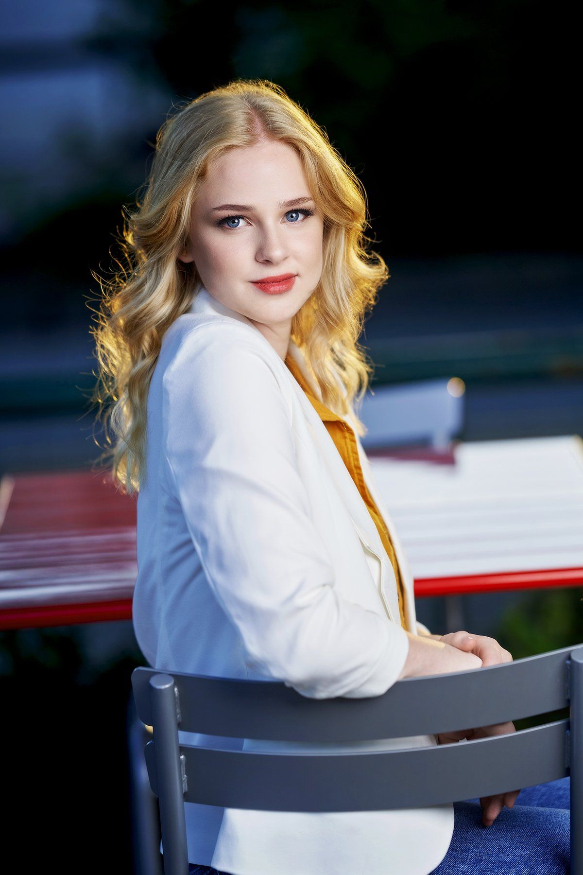 A young woman is sitting in a chair at a table.