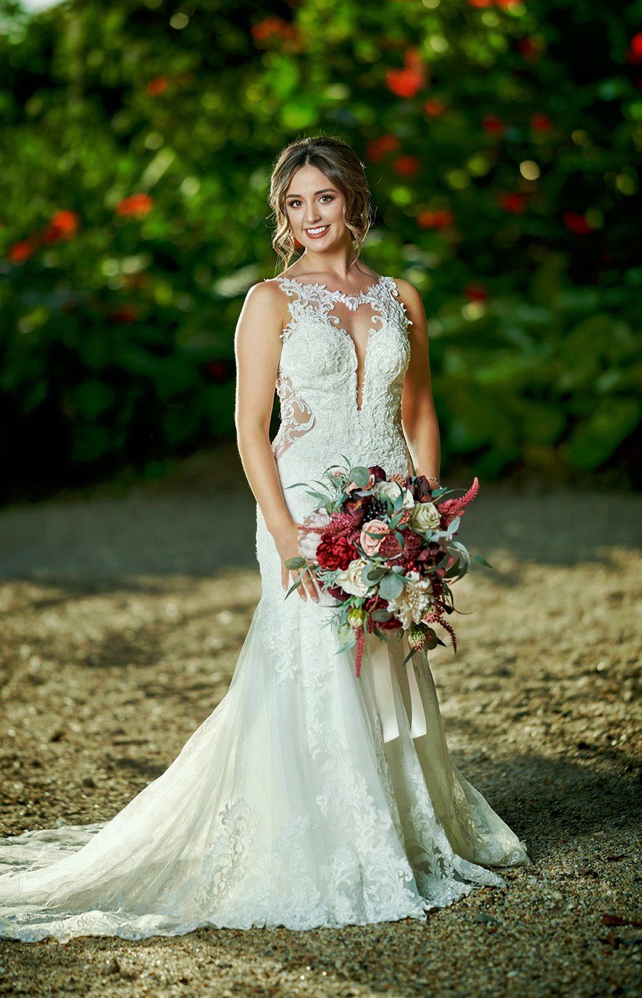 A bride in a wedding dress is holding a bouquet of flowers.