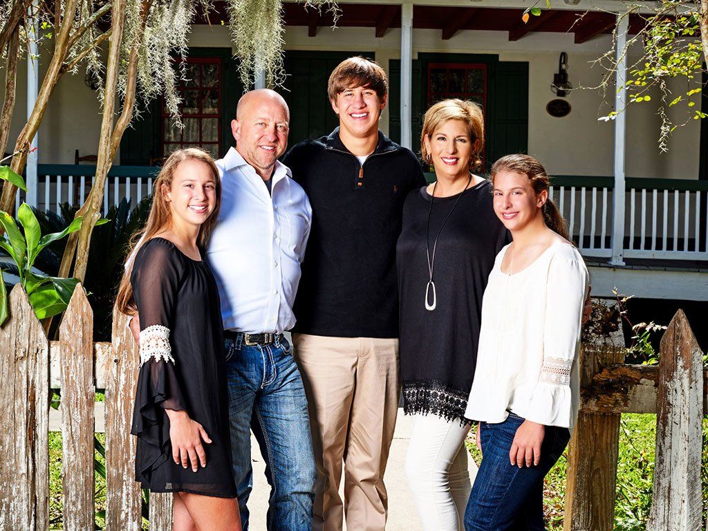 A family posing for a picture in front of a house
