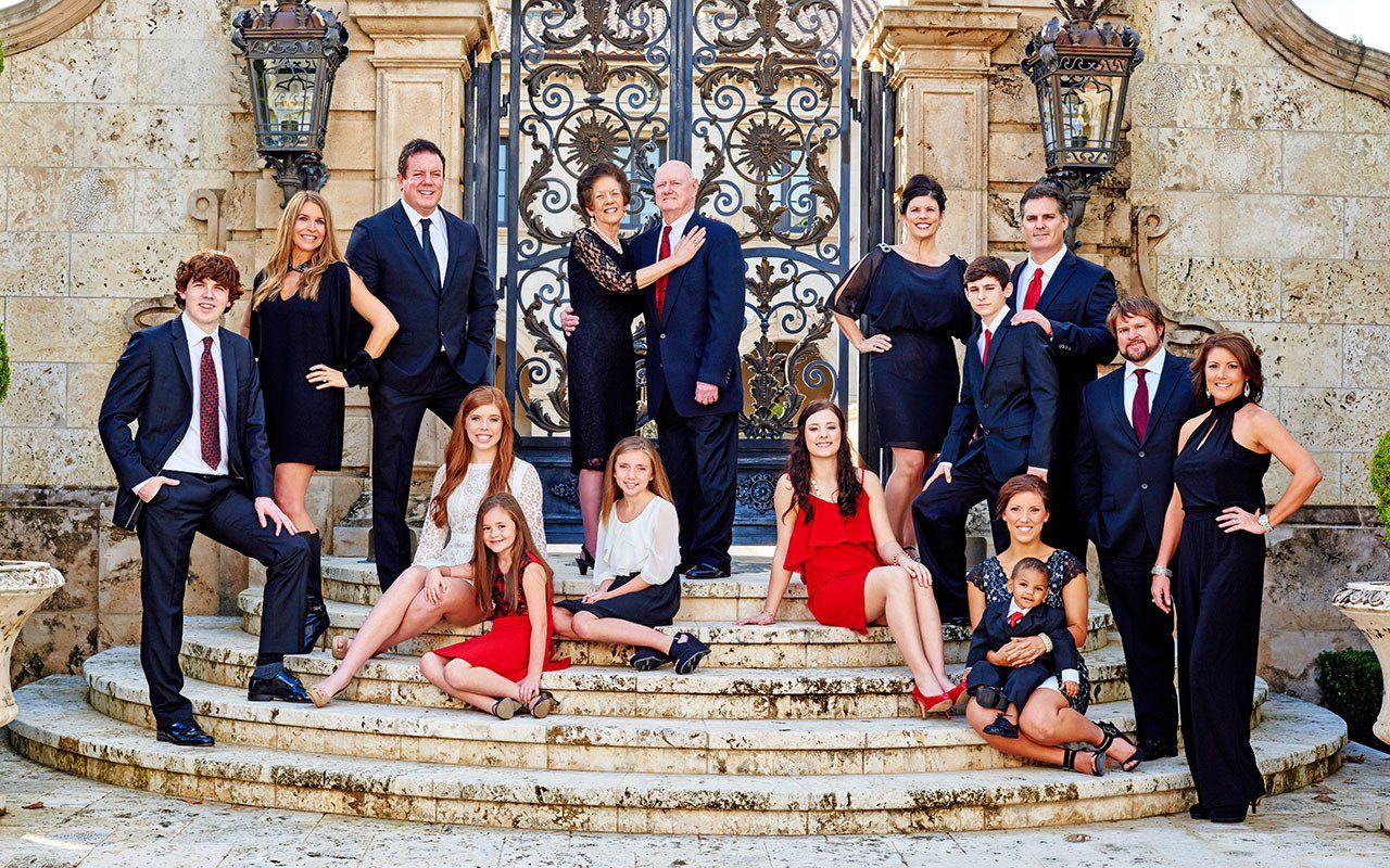 A large family is posing for a picture on the steps of a building.