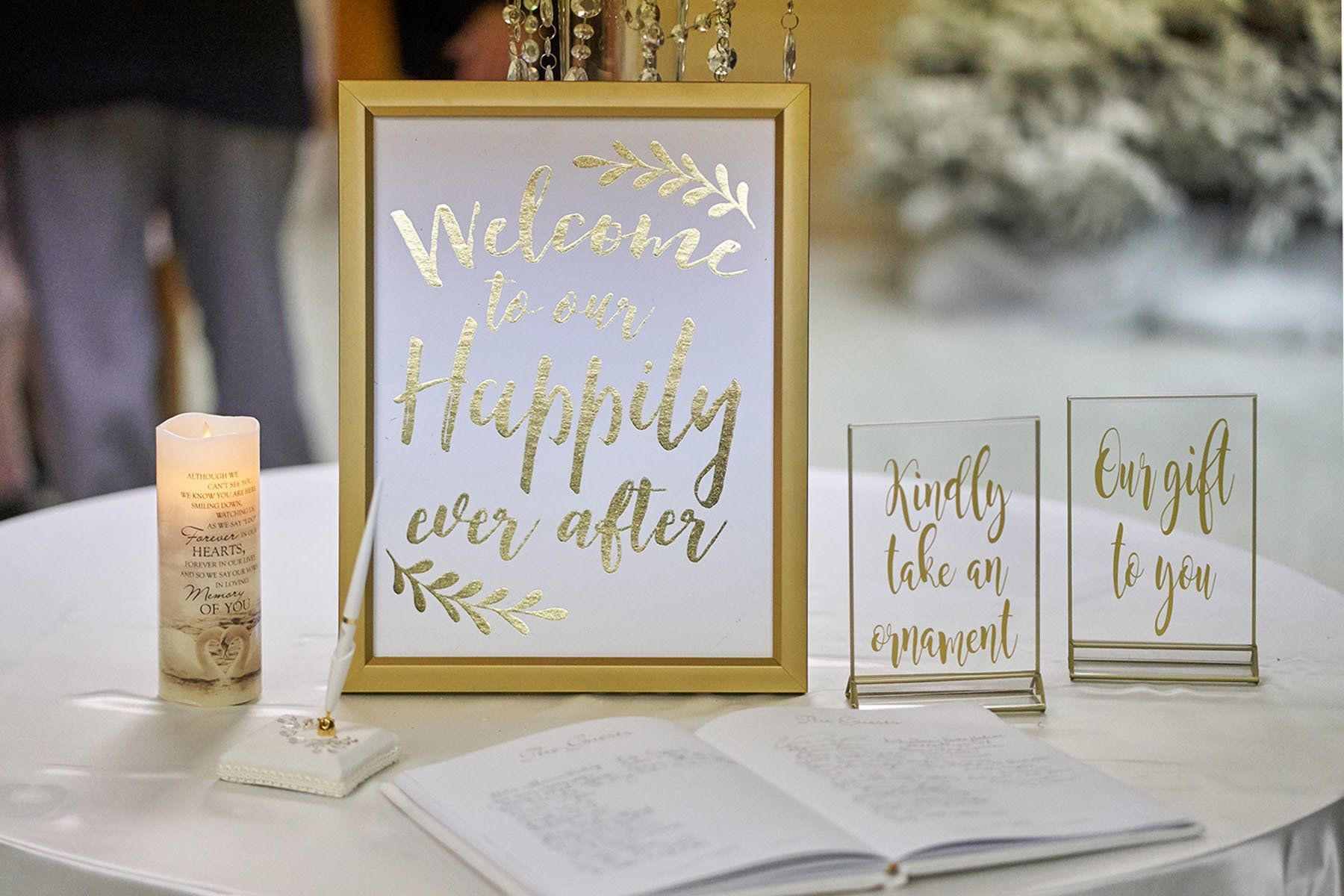 A table with a sign on it that says `` welcome to our happily ever after wedding ''.