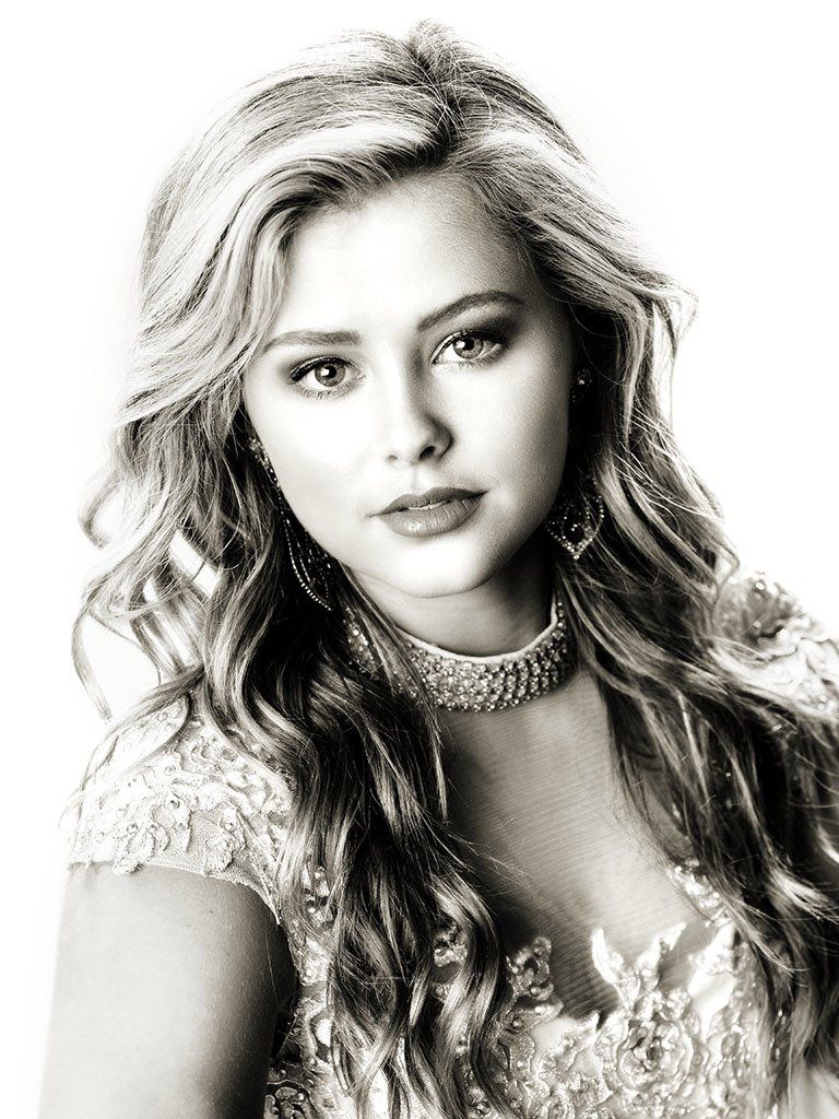 A black and white photo of a woman with long hair wearing a choker.