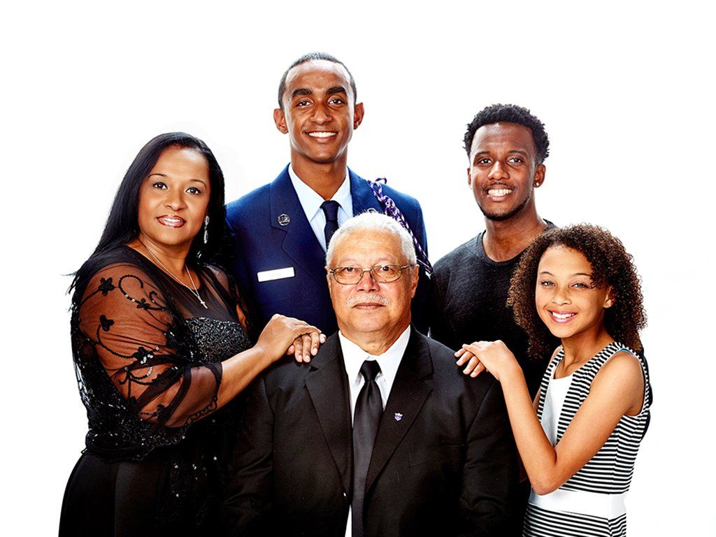 A family posing for a picture together on a white background.