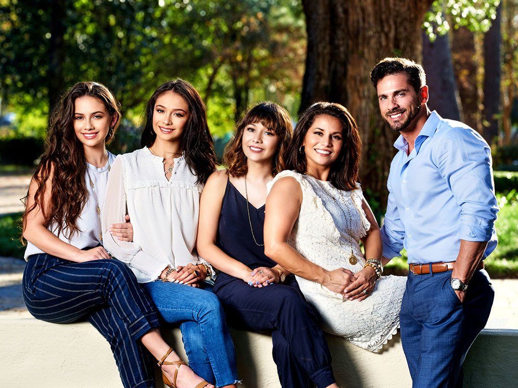A group of people are posing for a picture while sitting on a bench.