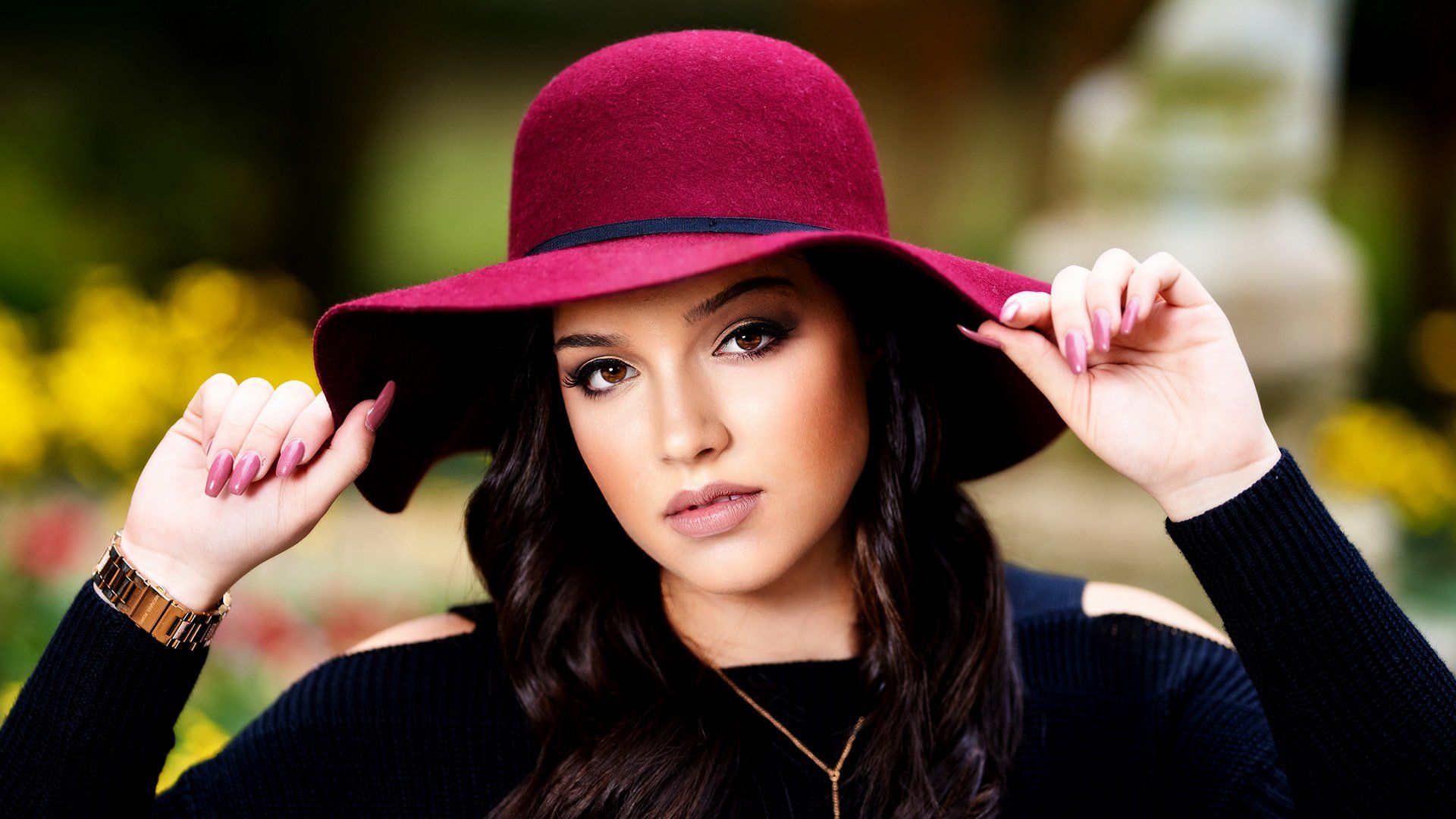 A woman is wearing a red hat and a black sweater.